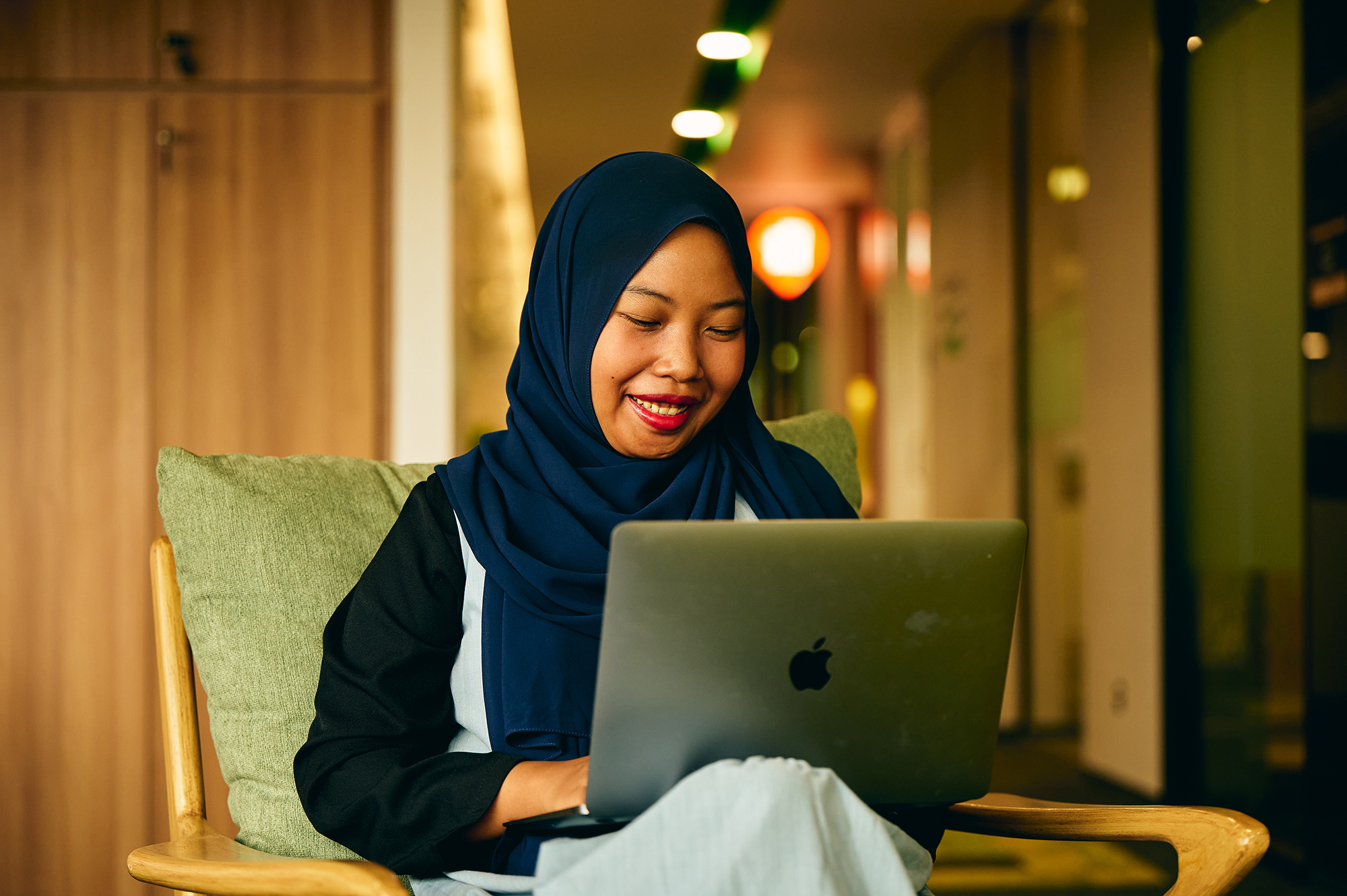 a woman sitting in a chair with a laptop