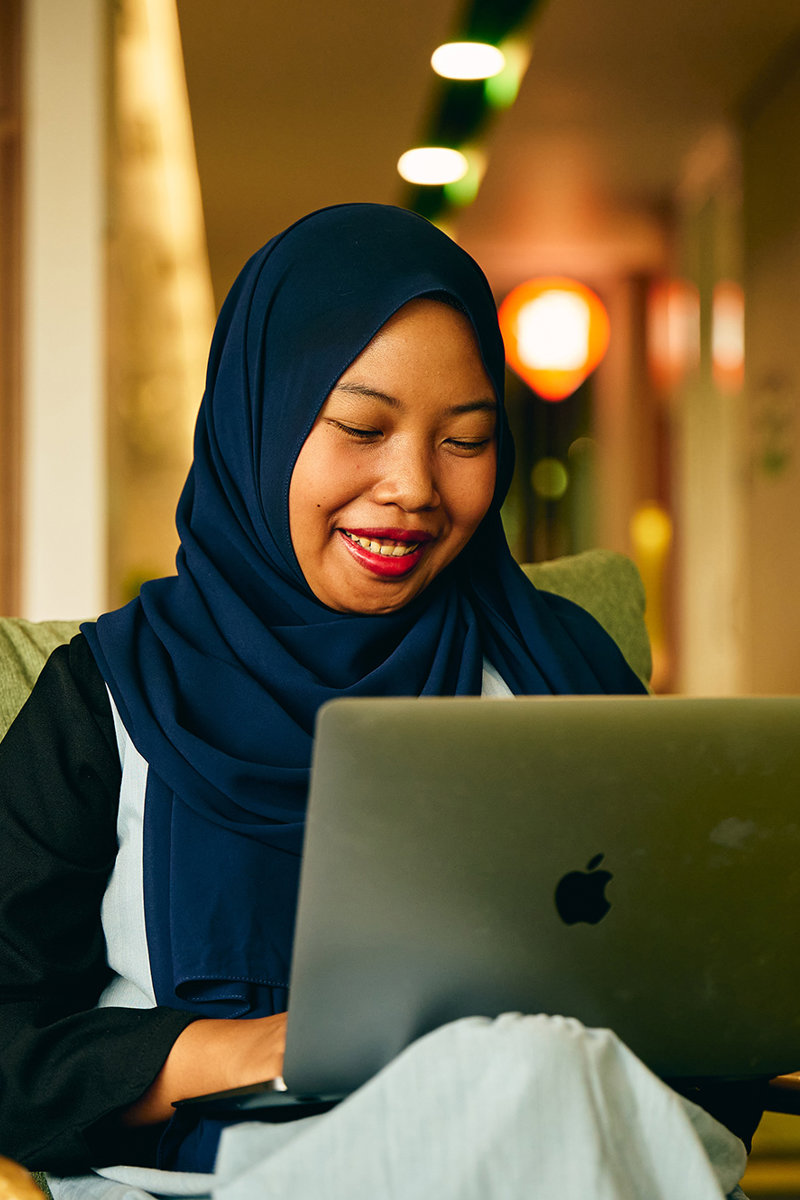 a woman sitting in a chair with a laptop