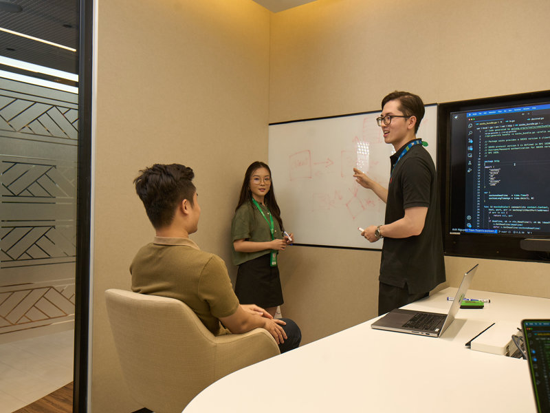 a person standing next to a whiteboard with a person pointing at it