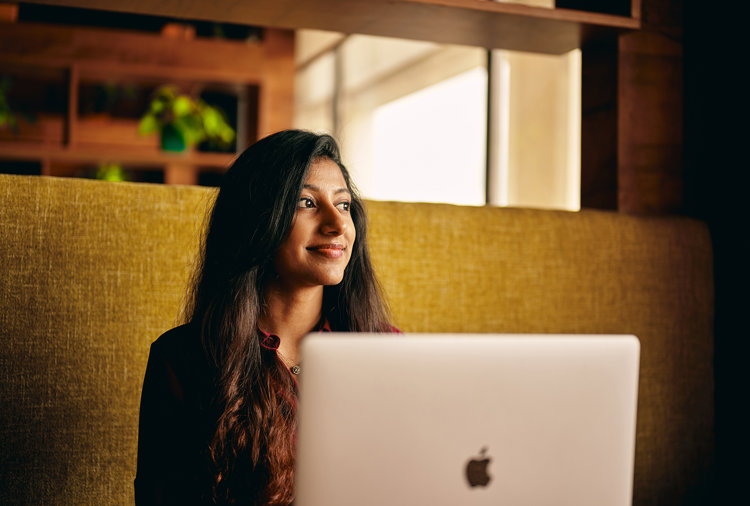 a woman looking away from a laptop