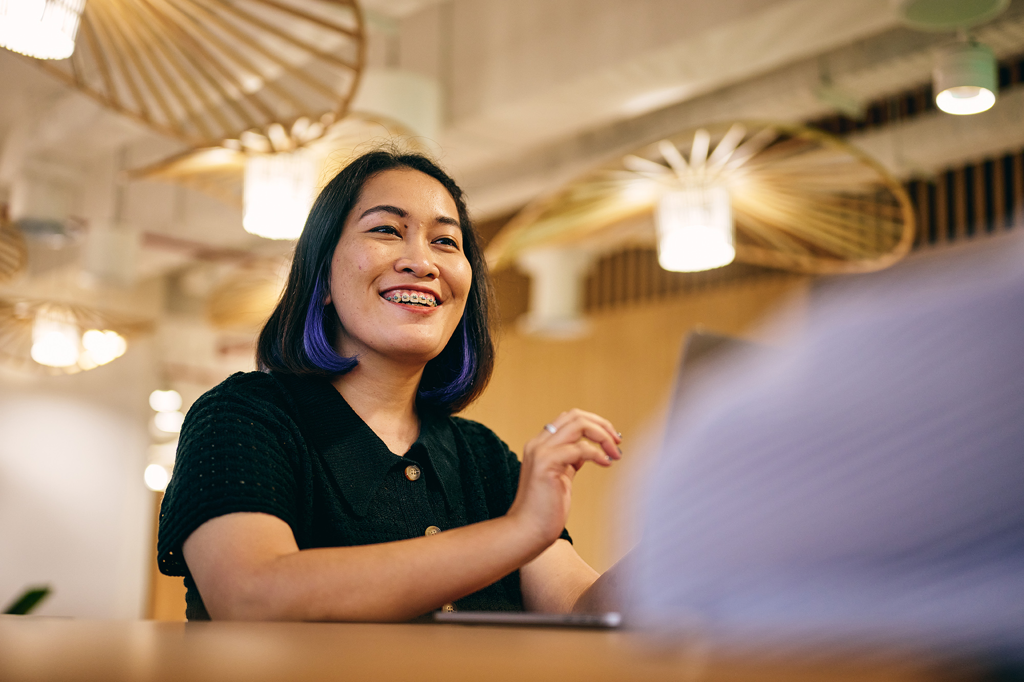a woman smiling at a laptop