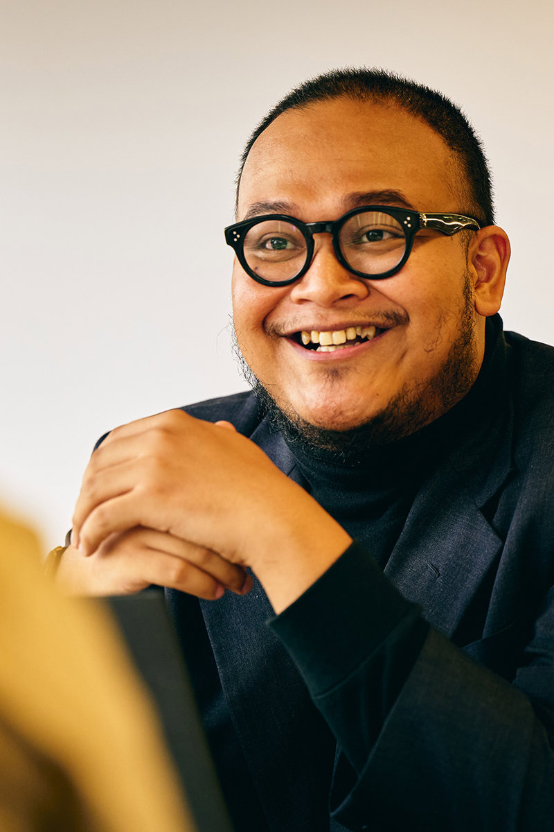 a man in glasses smiling