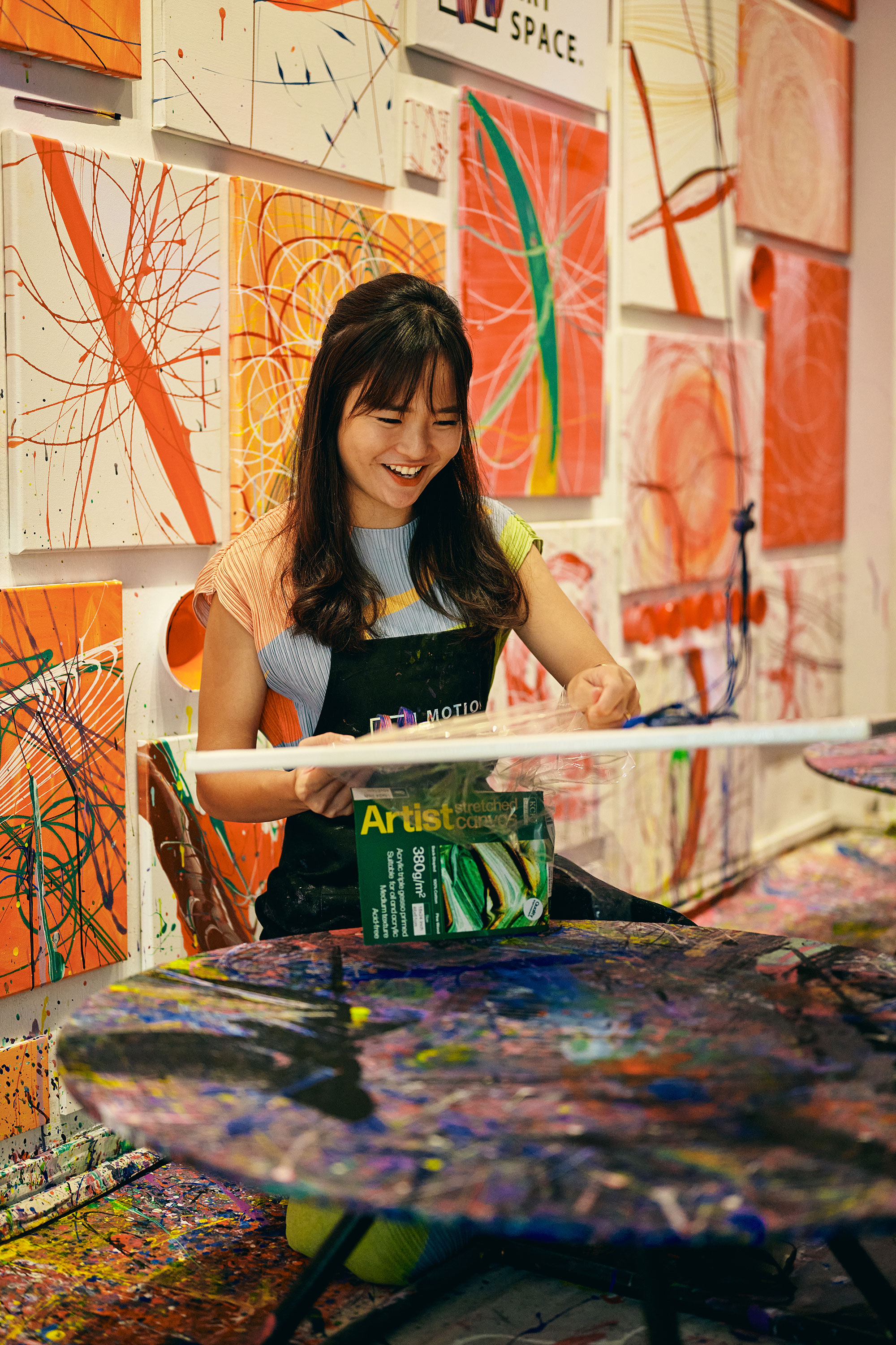 a woman sitting at a table with art on it