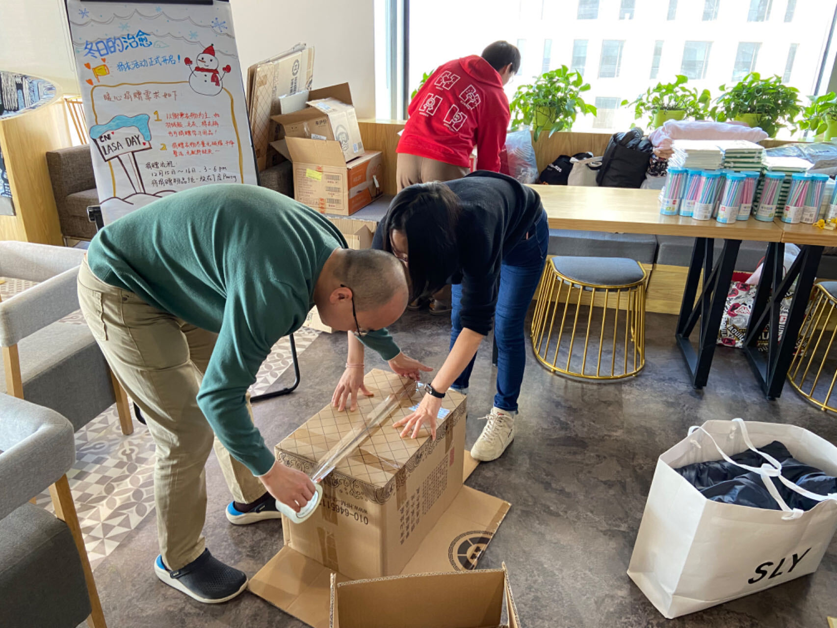 a man and woman packing a box