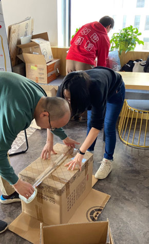 a man and woman packing a box