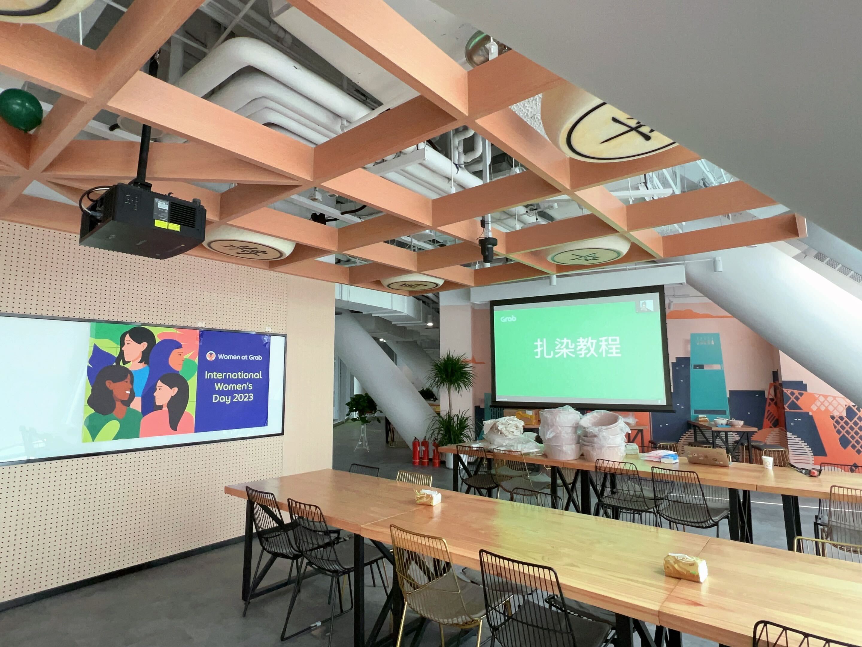 a room with tables and chairs and a projector screen