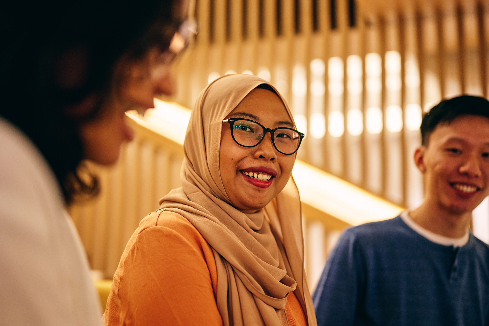 a woman wearing glasses and a scarf smiling