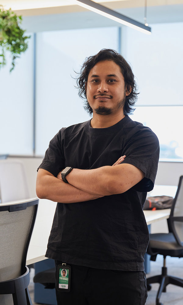 a man standing in an office with his arms crossed