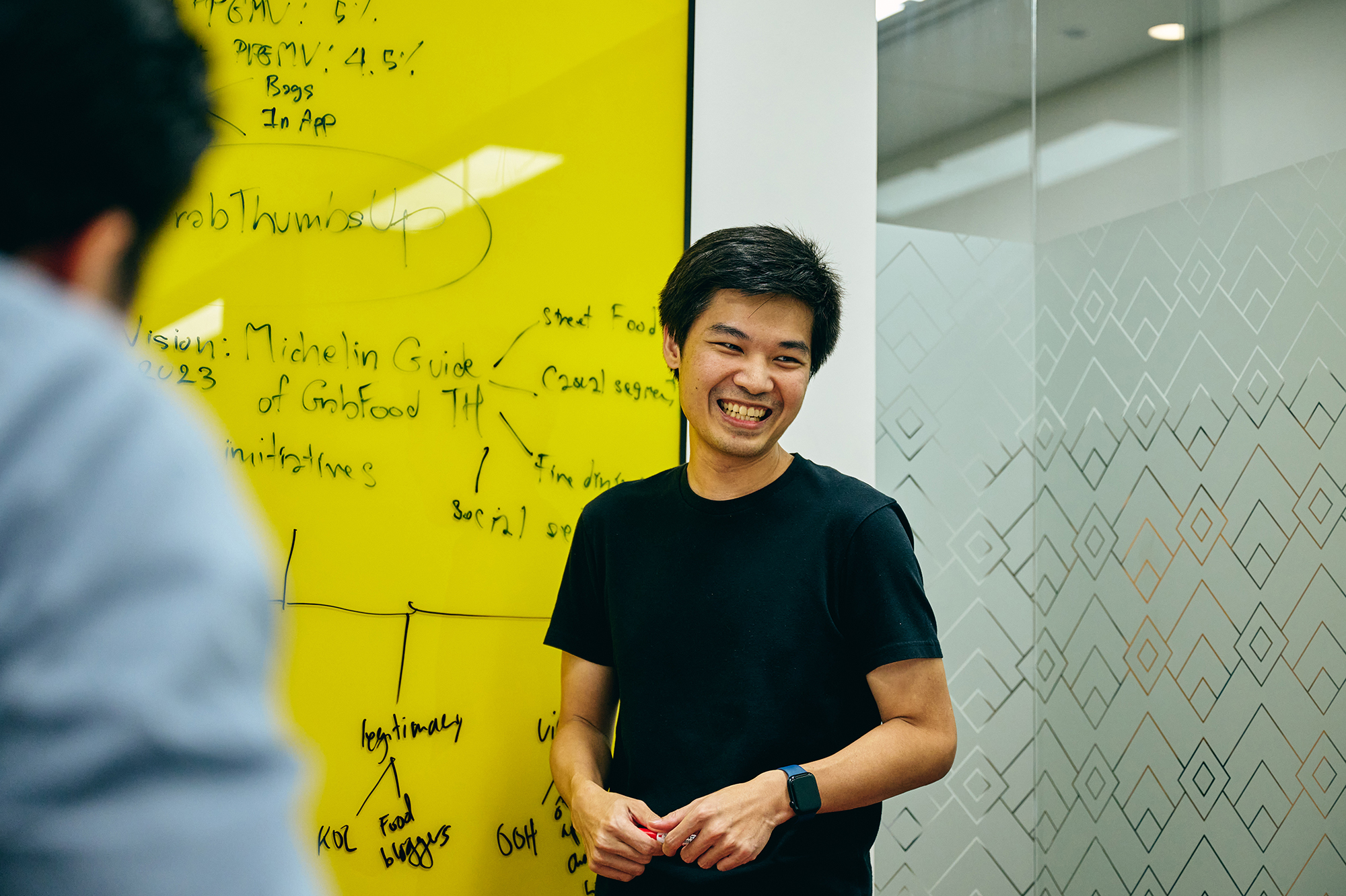 a man standing in front of a yellow board