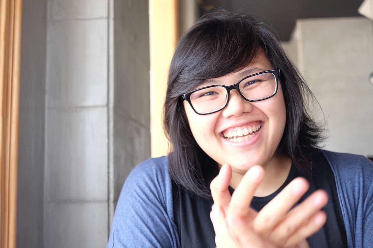 a woman smiling with her hand up