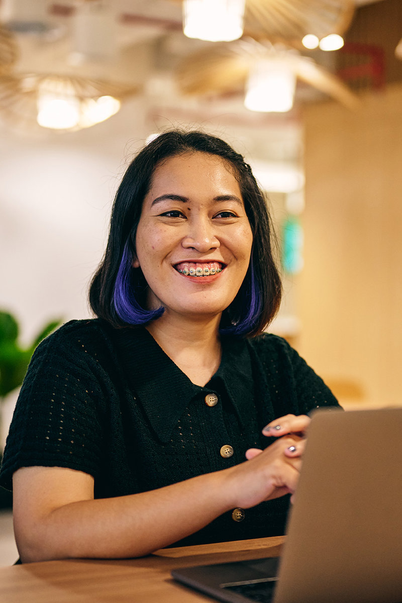 a woman smiling at a laptop