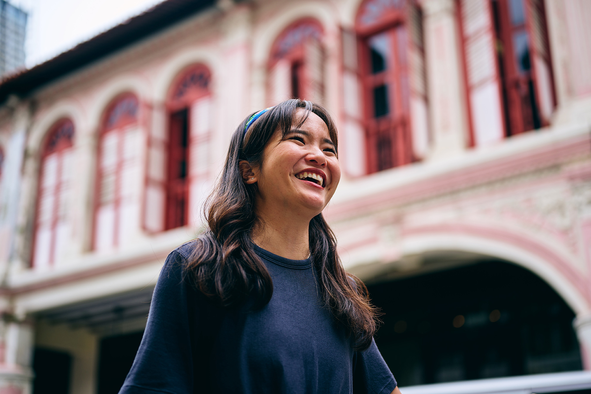 a woman smiling in front of a building