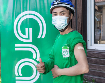 a man wearing a face mask and holding his thumb up