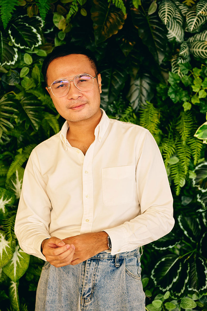 a man standing in front of a green wall