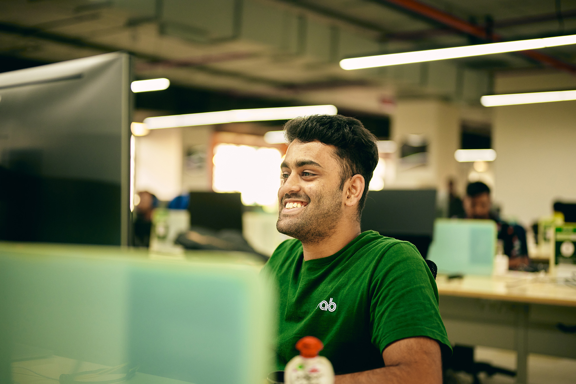 a man in a green shirt smiling