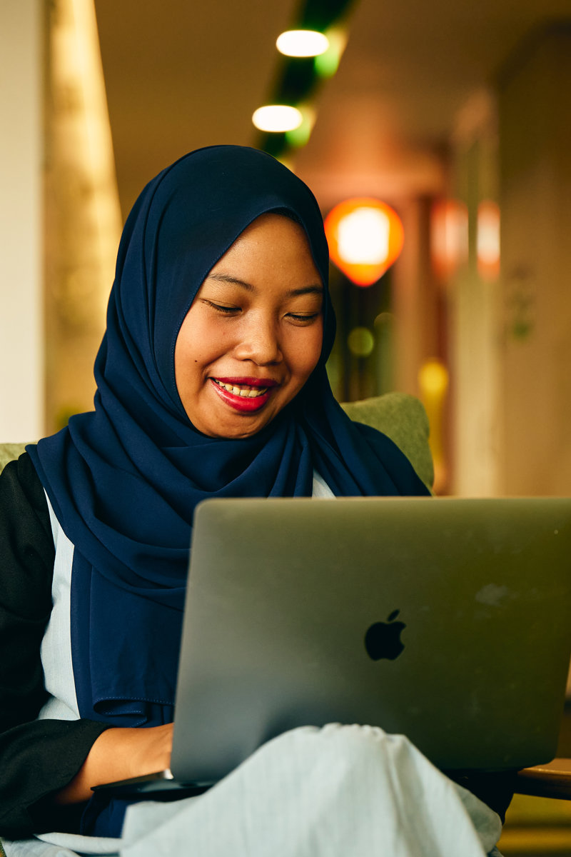 a person sitting on a chair with a laptop