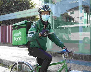 a person riding a bicycle with a food delivery box on his back