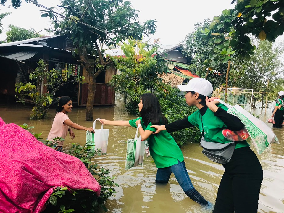 a group of people carrying shopping bags in a flooded area