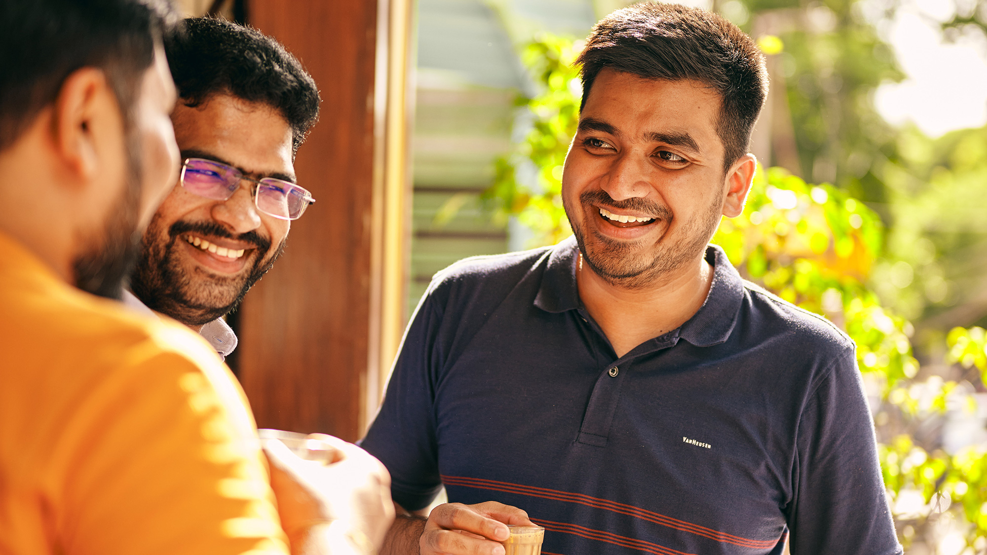 a group of men smiling and drinking