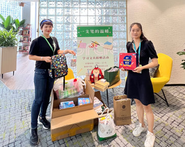 two women holding bags and a sign