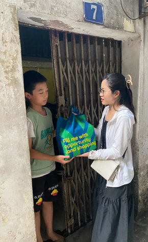 a woman holding a bag next to a boy