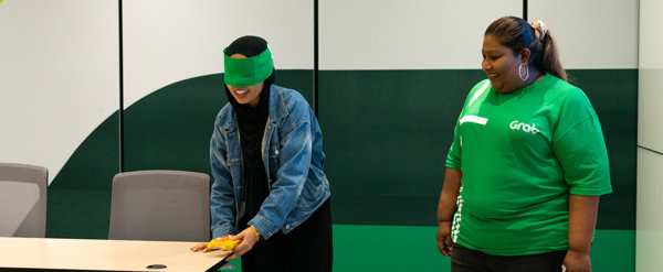 a person with blindfolded eyes standing next to a person