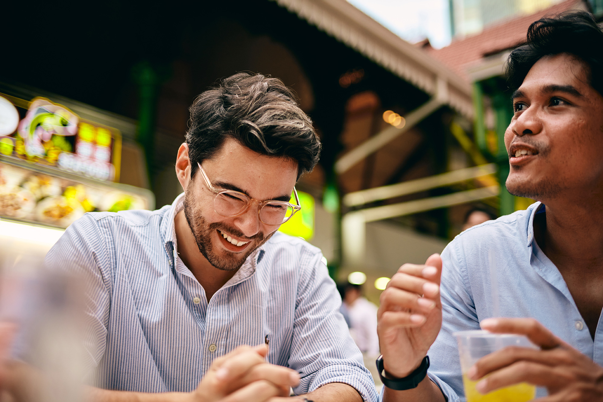 a man smiling while holding a cigarette