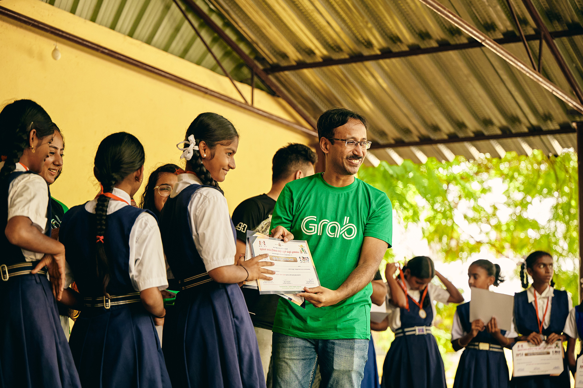 a man holding a paper with a group of girls in the background