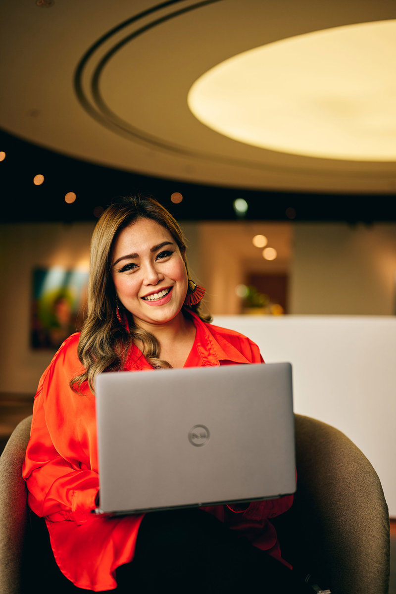 a woman sitting in a chair with a laptop