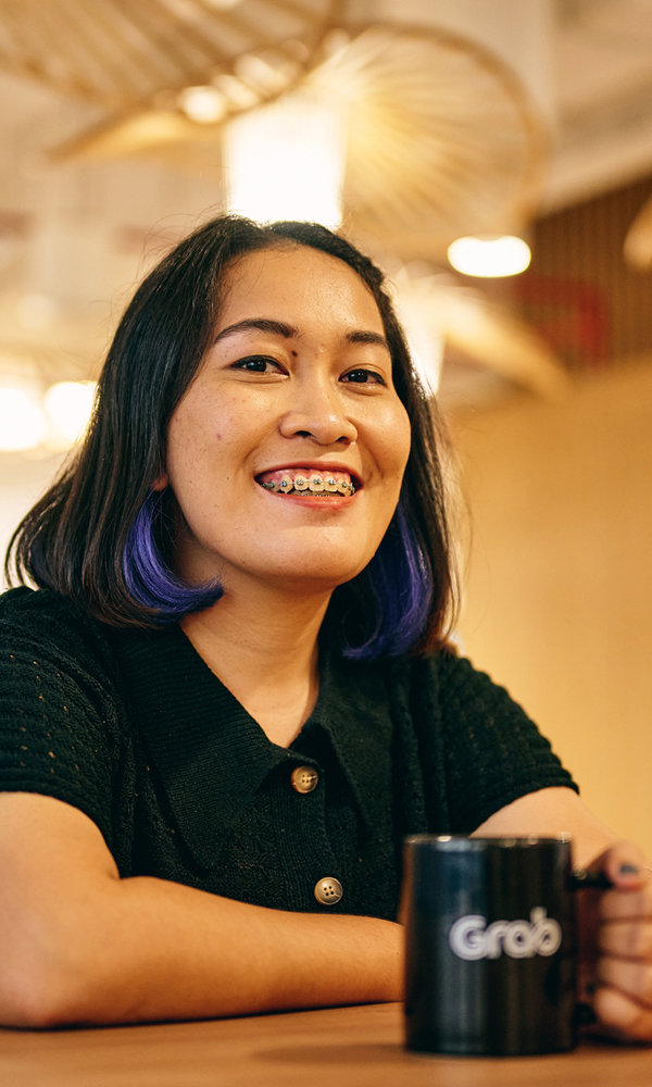 a woman sitting at a table with a mug