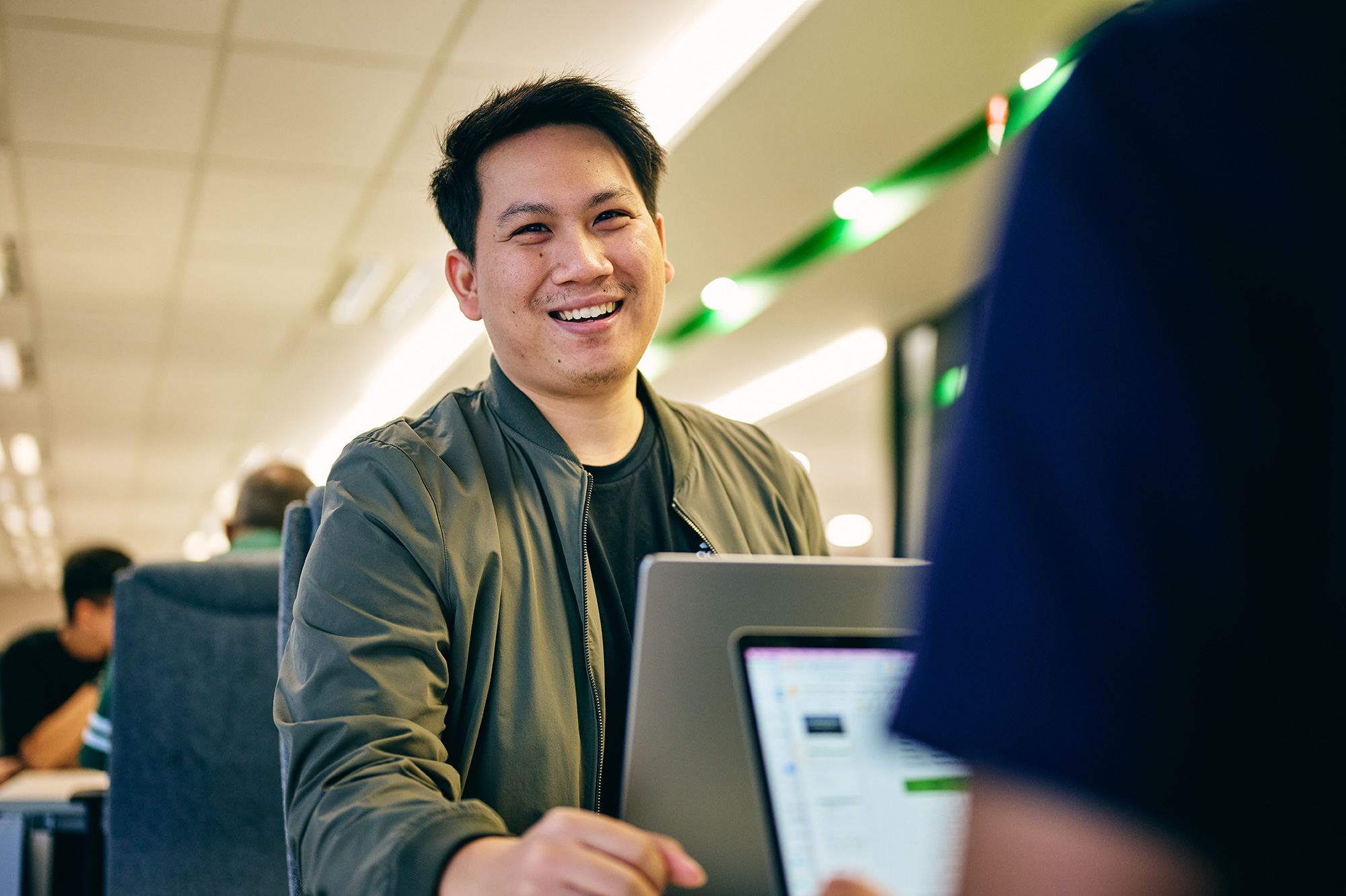 a man smiling at a laptop