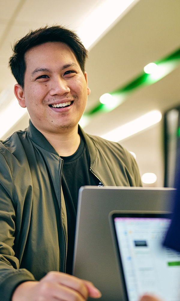 a man smiling at a laptop